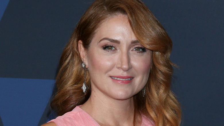 Sasha Alexander smiling in a pink dress