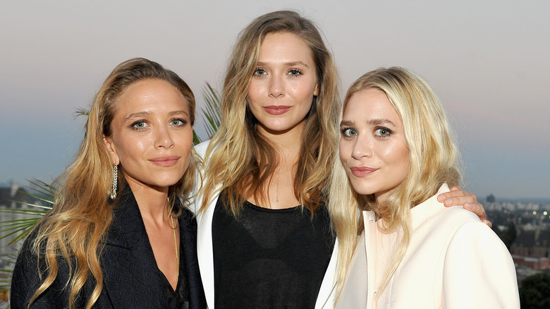 Elizabeth, Mary-Kate, and Ashley Olsen at an event 