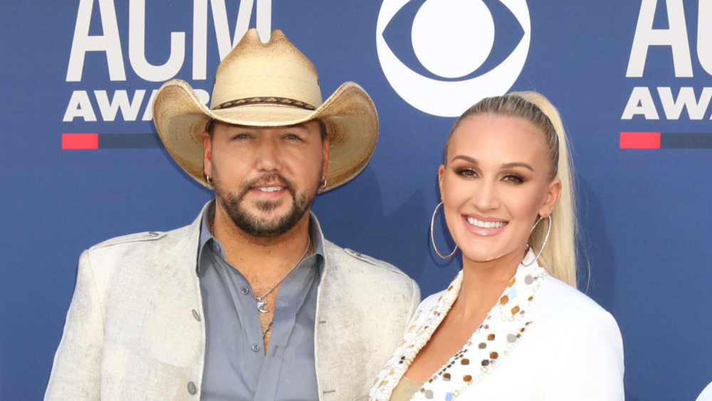 Jason Aldean at a red carpet event with wife Brittany