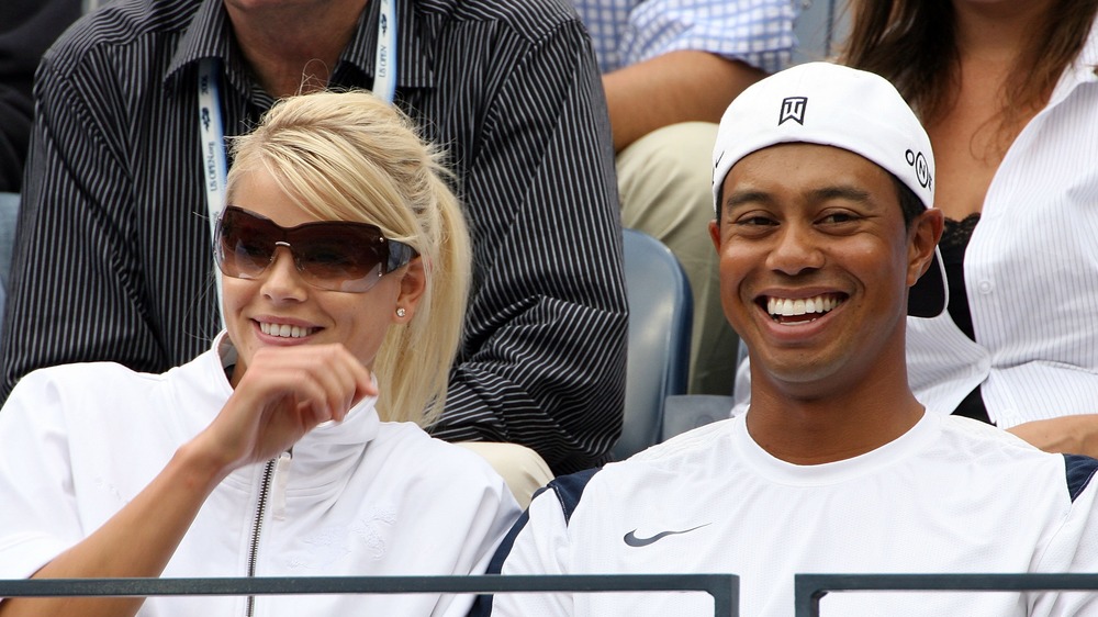 Elin Nordegren and Tiger Woods share a laugh at a sporting event