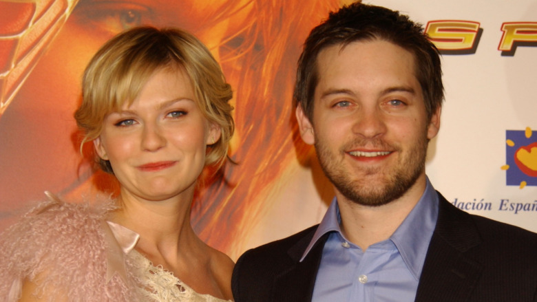 Kirsten Dunst, smiling, short blond hair, wearing dress, red carpet, with Tobey Maguire, smiling, no facial hair, wearing suit