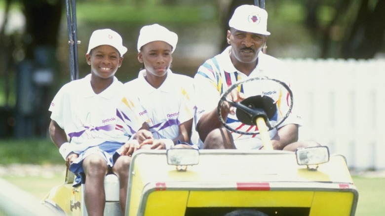 Serena and Venus Williams riding in golf cart with Richard Williams