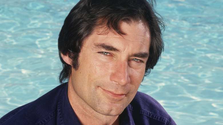 Timothy Dalton posing in front of a swimming pool