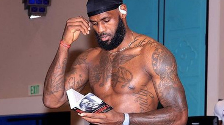 LeBron James reading with shirt off 