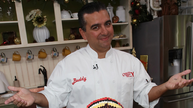 Buddy Valastro with a cake, smiling