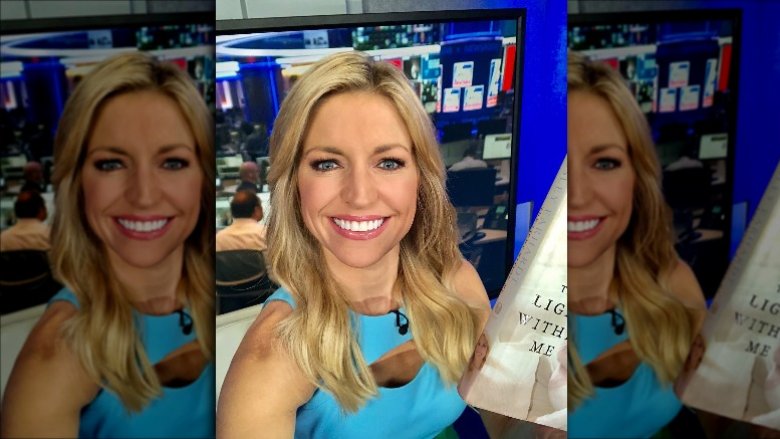 Ainsley Earhardt smiling and holding her book 