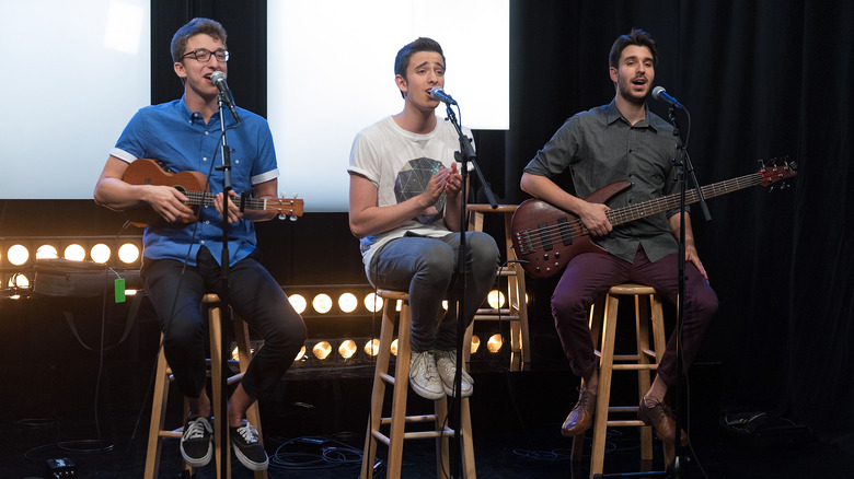 AJR performing on stools