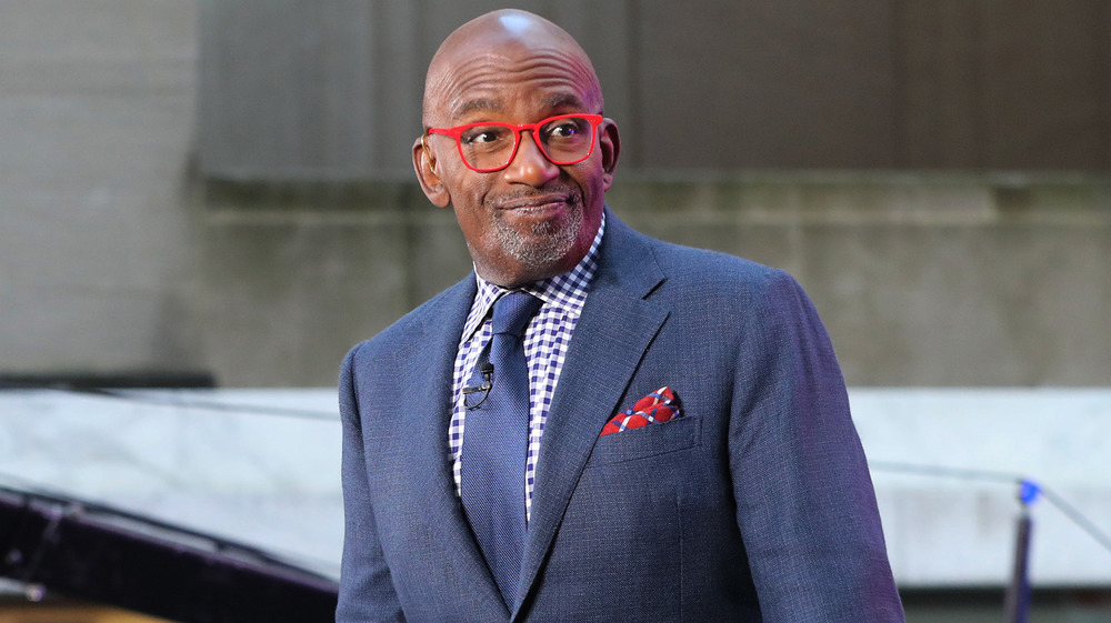 Al Roker smirking in red glasses 