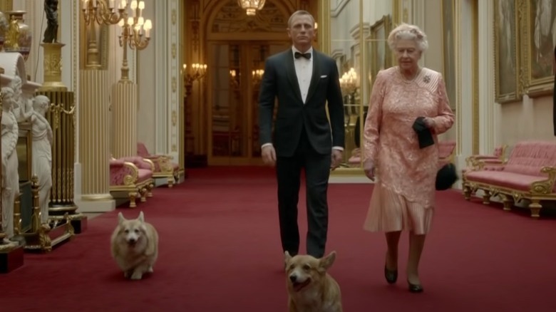 Daniel Craig walking with Queen Elizabeth and her corgis