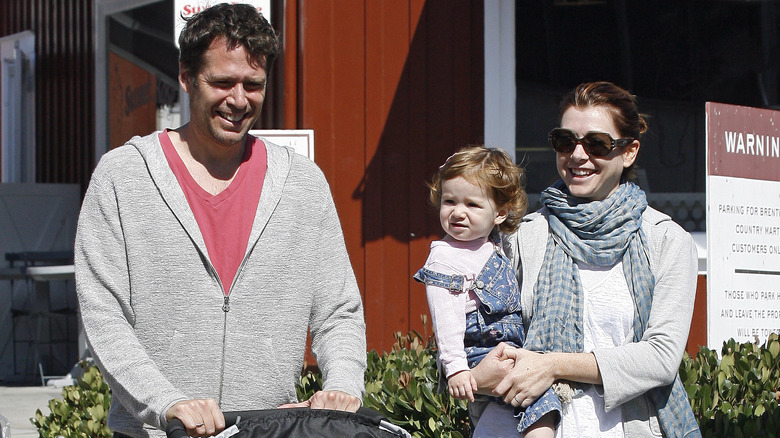 Alexis Denisof walking with Alyson Hannigan, holding daughter