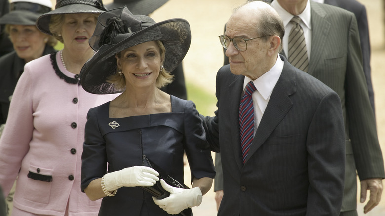 Andrea Mitchell smiling and walking with Alan Greenspan