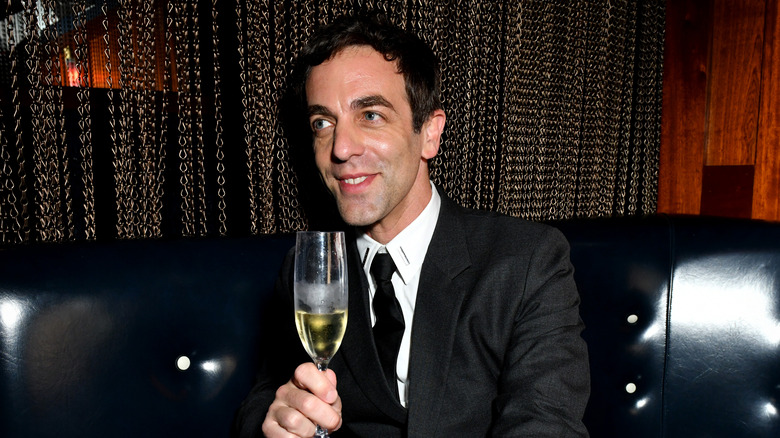 B.J. Novak smiling with a glass of champagne