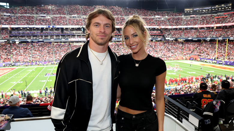 Braxton Berrios and Alix Earle smiling at a game