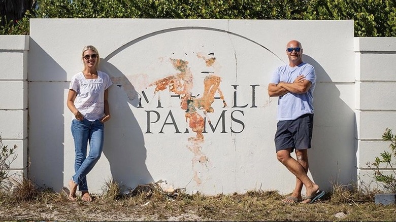 Sarah and Bryan Baeumler standing next to old resort sign