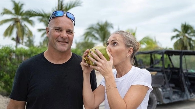 Bryan Baeumler smiling, Sarah Baeumler drinking out of a coconut