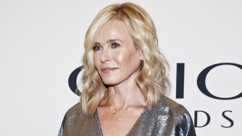 Chelsea Handler in a sparkly, silver pantsuit, with a neutral expression