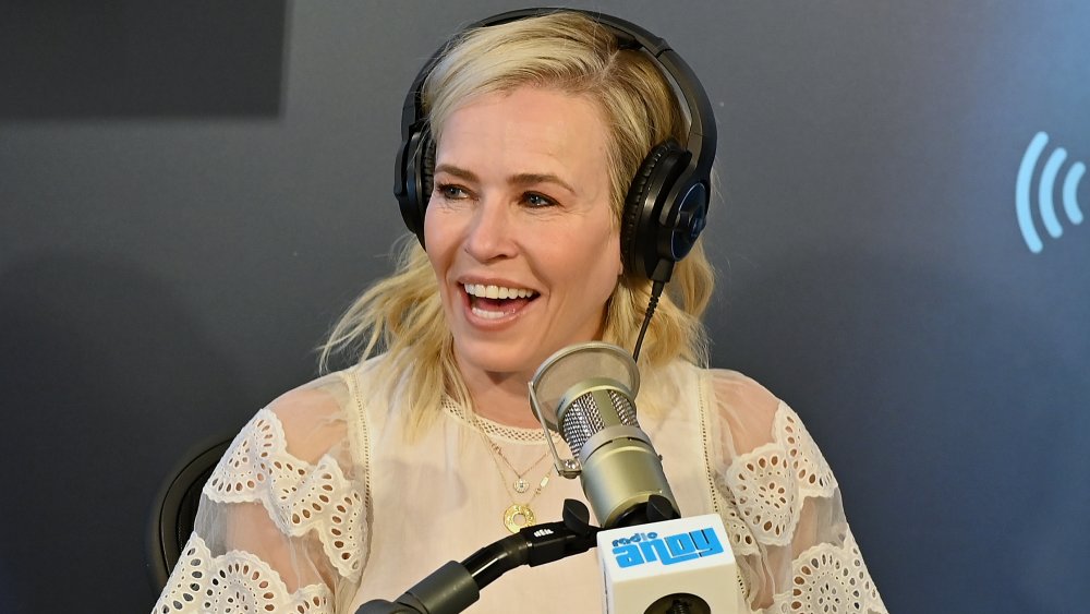 Chelsea Handler in a white blouse and headphones, laughing on Andy Cohen's Sirius XM show