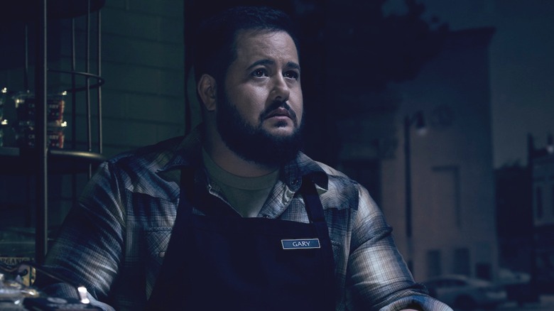 Chaz Bono as Gary in American Horror Story standing in a darkened grocery store