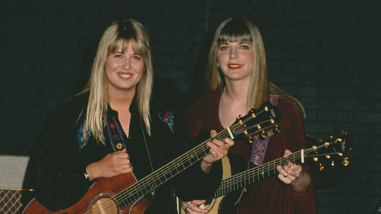 Chaz Bono and Heidi Shink smiling while holding guitars