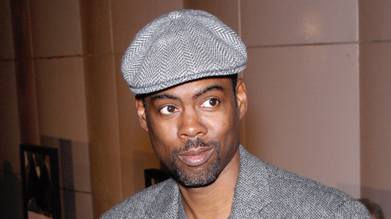 Chris Rock in a gray hat and suit