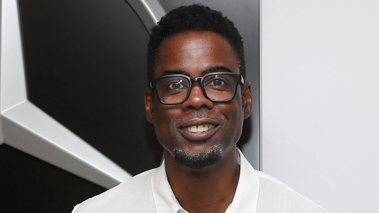 Chris Rock smiling, with glasses on