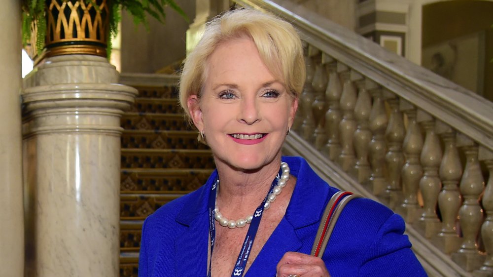 Cindy McCain smiling in a blue dress and pearls