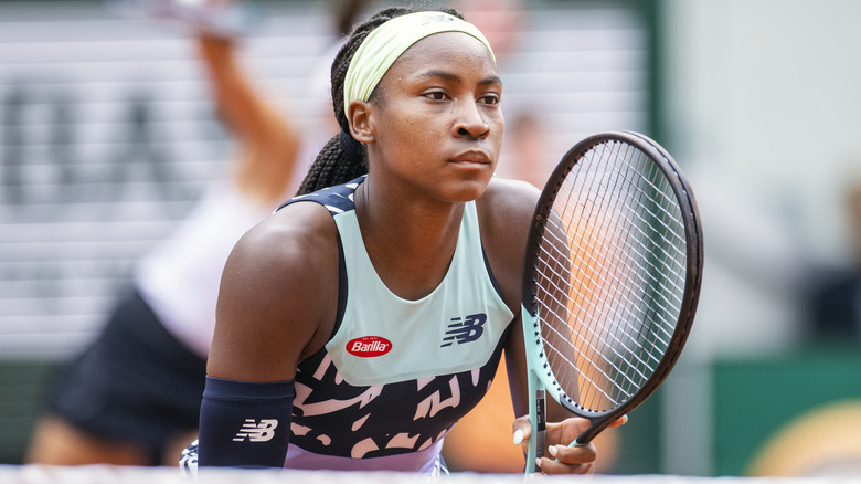 Coco Gauff standing on the tennis court holding her racket ready to play