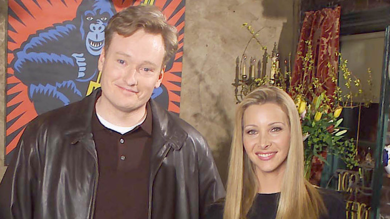 Conan O'Brien smiling next to Lisa Kudrow