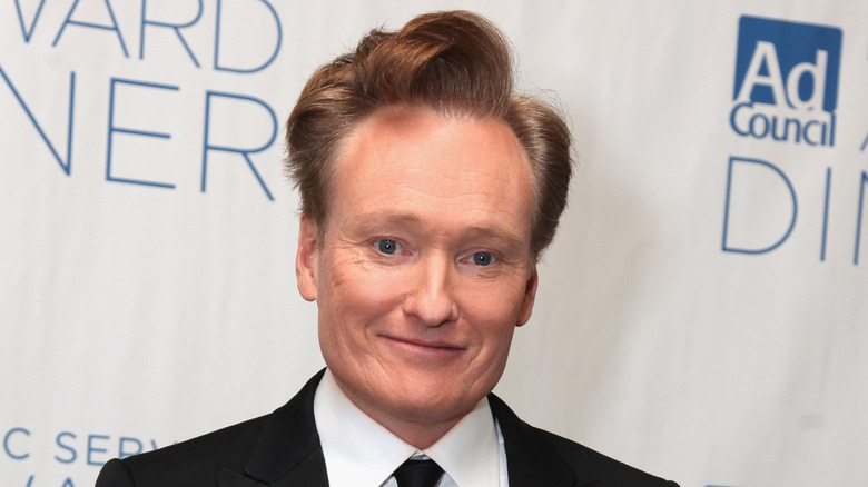 Conan O'Brien in a white dress shirt, smiling