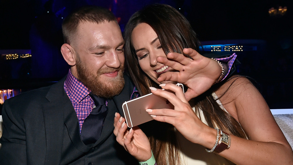 Connor McGregor and Dee Devlin look at her phone