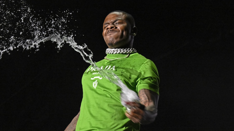 DaBaby sprays liquid from a bottle during an April 2022 performance