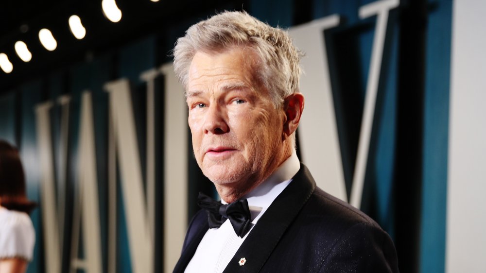 David Foster dressed in a black suit with white shirt and black bow tie, posing with a neutral expression on the red carpet