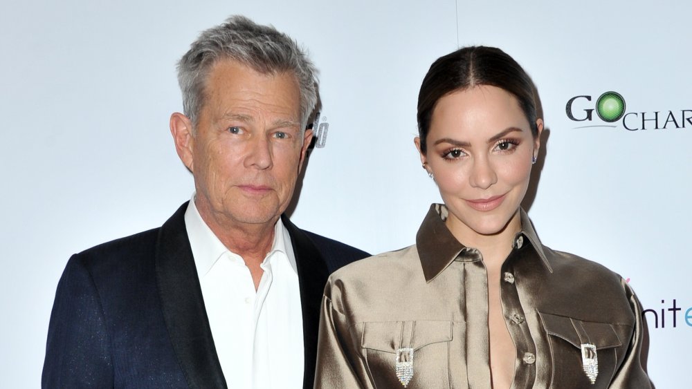 David Foster in a dark blue blazer, Katharine McPhee in a shiny, golden jumper, posing together at an event