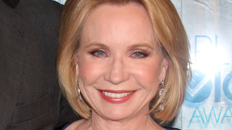 Debra Jo Rupp posing in front of a step and repeat