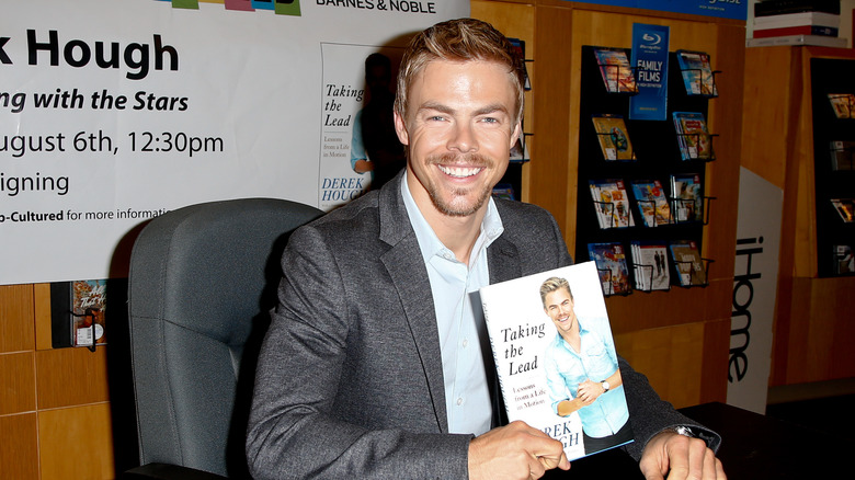 Derek Hough posing with his book