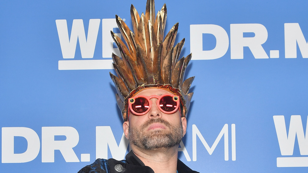 Dr. Miami wearing a crazy hat and sunglasses on the red carpet