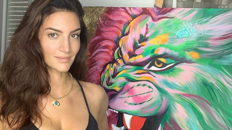 Sophie Brussaux standing next to a painting of a tiger