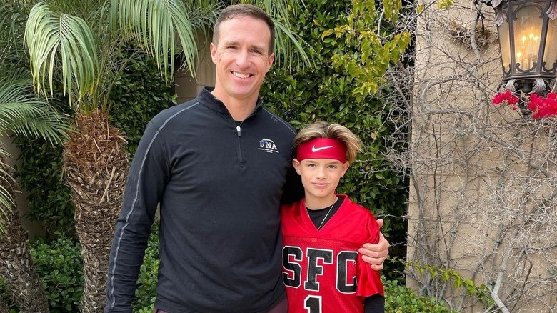 Drew Brees, posing with his son Baylen