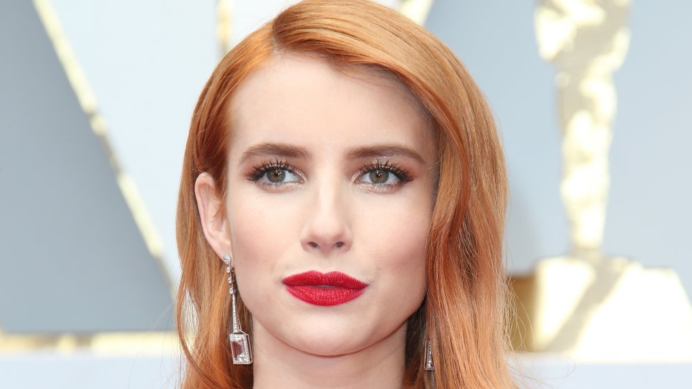Emma Roberts posing on the red carpet with a neutral expression