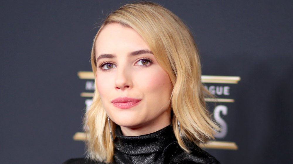 Emma Roberts posing on the red carpet with a neutral expression