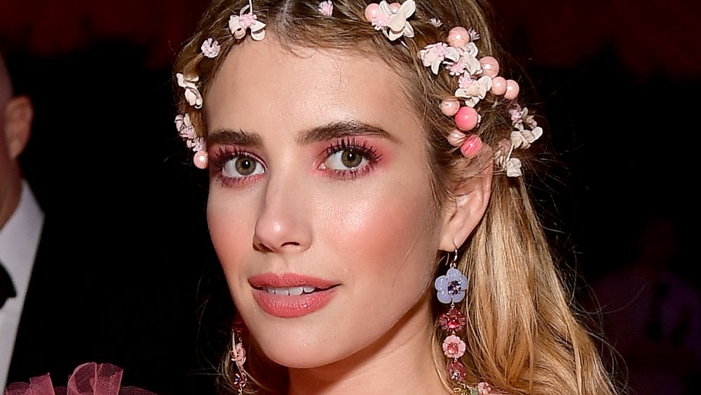 Emma Roberts staring straight at the camera, wearing a flower crown