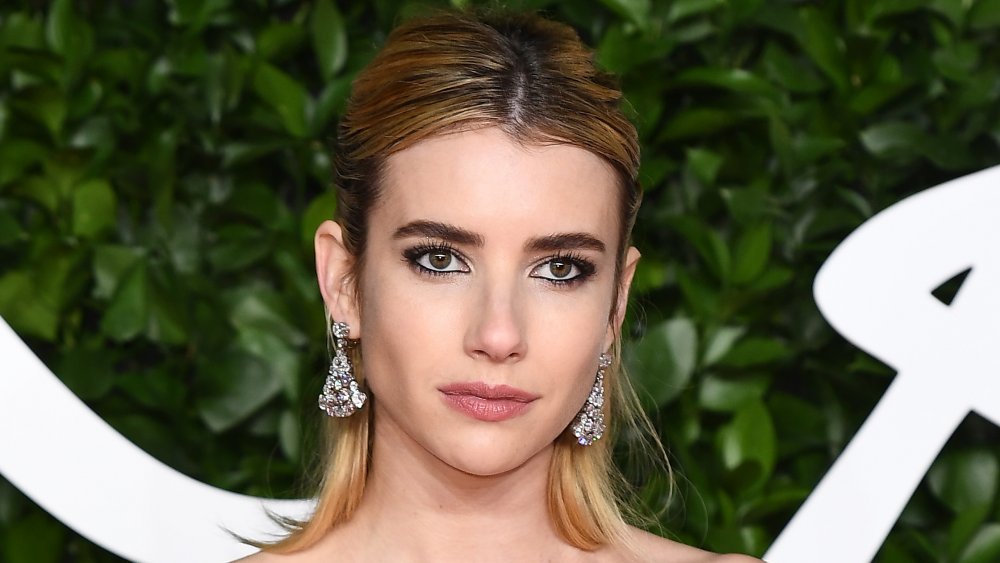 Emma Roberts posing on the red carpet with a neutral expression