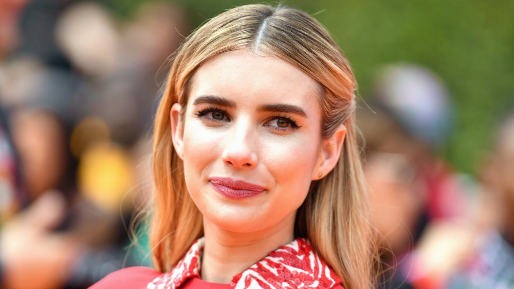 Emma Roberts smirking and looking off to the side at an event