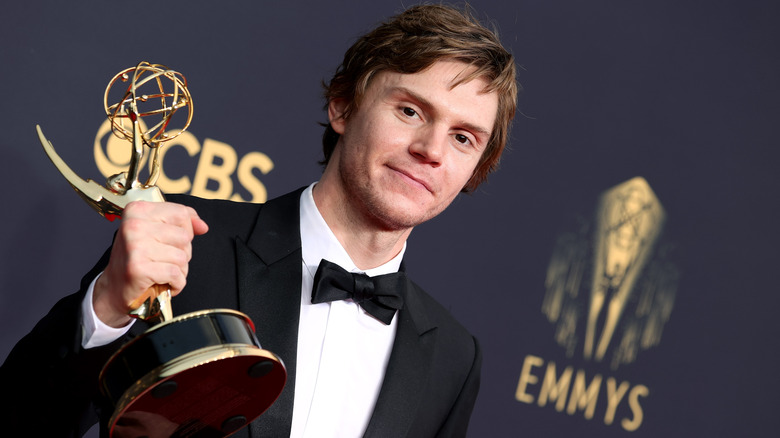 Evan Peters holding his Emmy