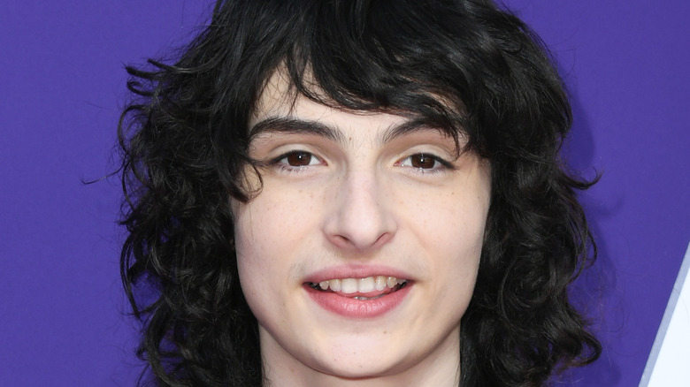 Finn Wolfhard smiling at event