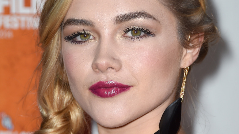 Florence Pugh with a large black earring, posing