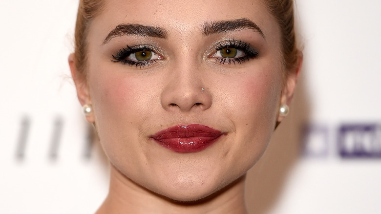 Florence Pugh with red lipstick, smiling