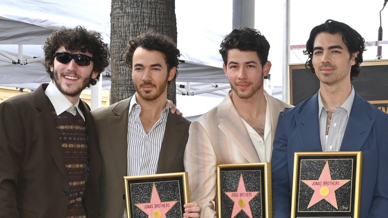 Frankie posing with his brothers as Kevin, Nick, and Joe hold Hollywood stars