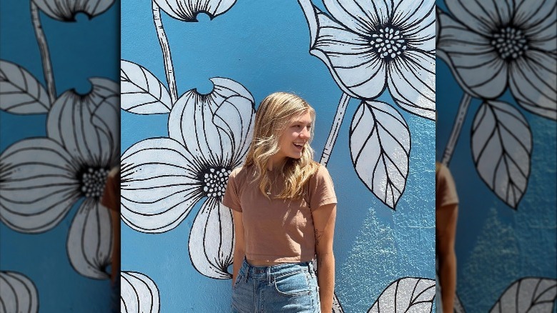 Gabby Petito smiling with floral mural in background