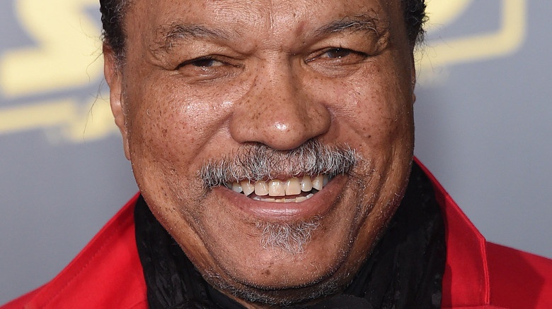 Billy Dee Williams wearing a red jacket